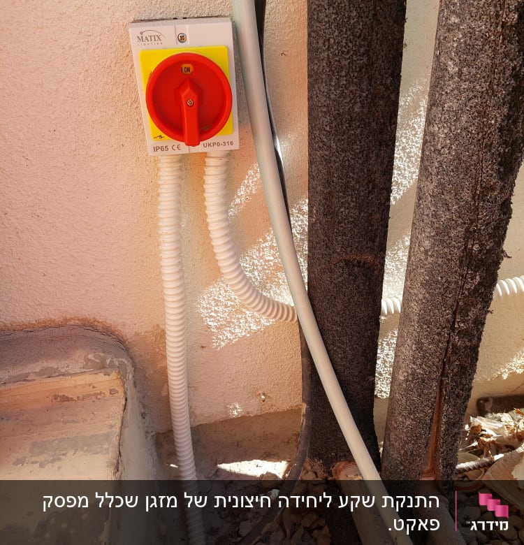 מתג חשמלי עם כבל גמיש על קיר חיצוני